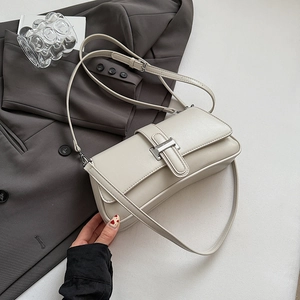 Detail of cream white leather baguette bag with silver metal buckle and adjustable strap