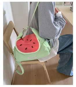 Detail showing the watermelon-themed green crossbody bag with cute embroidery and strap