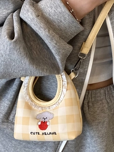 Mini yellow checkered bucket bag with dog embroidery and ruffle handle detail