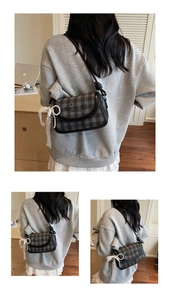 Nahaufnahme der Vintage-Karotasche mit eleganter Spitzenschleife und Perlenanhänger