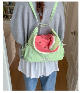 Detail of watermelon themed nylon backpack with pink embroidery and cute plush charm