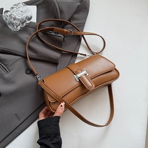 Detail view of brown vintage underarm bag with silver buckle and adjustable strap