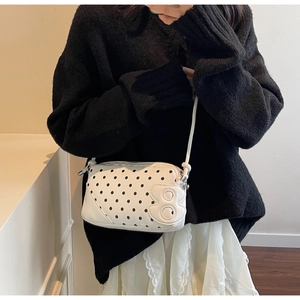 Close-up of stylish polka dot shoulder bag with unique number 8 relief detail