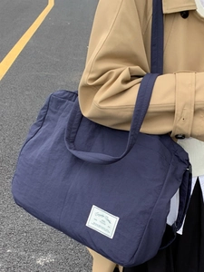 Large navy blue nylon tote bag for women featuring a wide shoulder strap and casual design