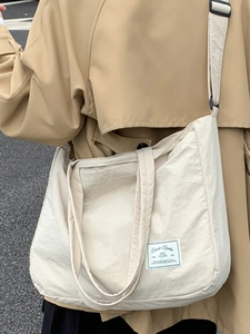Minimalist cream canvas tote bag for women with wide shoulder strap in street style