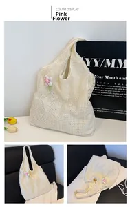 Detail of beige lace tote bag with delicate floral embroidery and pink flower pendant