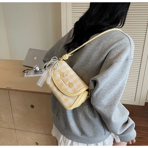 Detail of yellow gingham shoulder bag with heart embroidery and pearl lace charm