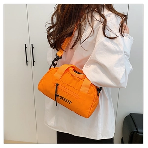 Détail de la sacoche en nylon orange avec logo QYSSYP et boucles métalliques noires