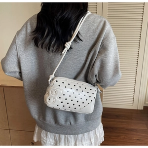Detail of white polka dot bag with a unique number 8 embossing and slim rope shoulder strap