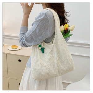 Detailed shot of white floral lace tote bag with crochet texture and tulip decoration