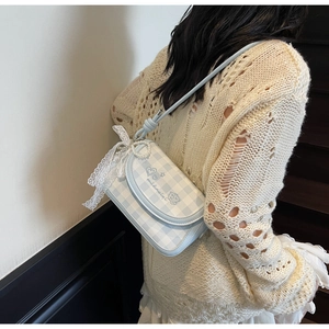 Chic light blue plaid shoulder bag with pearl charms and lace bow on a model