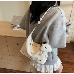 Détail du sac à bandoulière brillant crème avec papillons et bijou de sac nuage