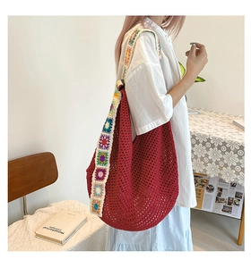 Détail du sac fourre-tout au crochet rouge avec bandoulière large brodée de fleurs