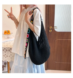 Détail du sac cabas en crochet noir avec motifs de tournesols colorés sur la bandoulière