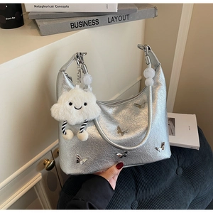 Détail du sac argenté en cuir froissé avec papillons métalliques et charm nuage en peluche