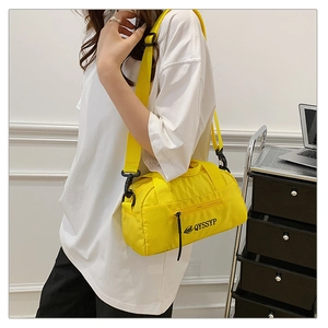 Détail du mini sac cylindrique jaune en nylon alvéolé avec bandoulière et zip