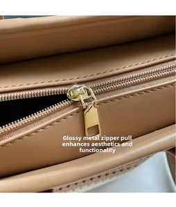 Close-up of golden metal zipper and smooth light brown leather on a straw bucket bag