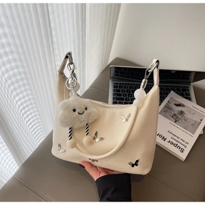 Détail du sac beige avec papillons argentés et pendentif nuage en peluche doux