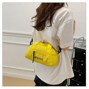 Vue latérale du sac bandoulière jaune en nylon avec texture et détails du logo de marque