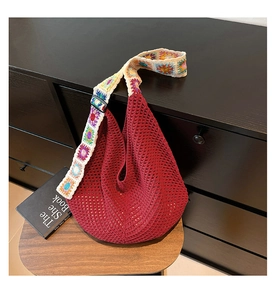 Détail du sac cabas tissé rouge vin avec une bandoulière colorée au crochet à motifs floraux