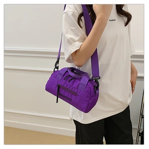 Vue détaillée du sac à bandoulière cylindrique violet en nylon imperméable