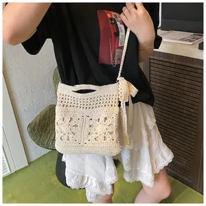 Gros plan détaillé du motif floral au crochet et du nœud en dentelle blanche sur le sac