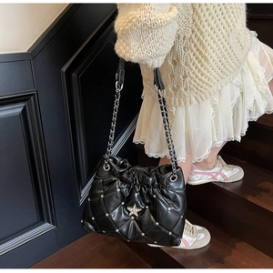 Détail du sac à bandoulière matelassé noir avec étoile en cristal et chaîne élégante