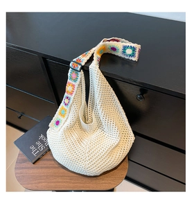 Détail du sac hobo en crochet blanc avec une bandoulière colorée à fleurs arc-en-ciel