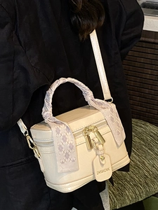 Beige box-shaped crossbody bucket bag with silk scarf handle and gold zippers