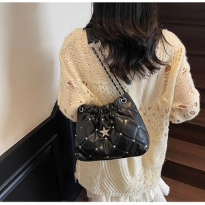 Détail du sac à bandoulière matelassé noir avec clou en étoile et bandoulière en chaîne argent