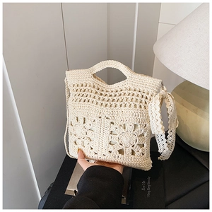 Gros plan du sac en crochet crème fait main avec motifs floraux creux et ruban en dentelle
