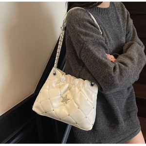 Détail du sac à bandoulière matelassé blanc avec étoile argentée et strass brillants