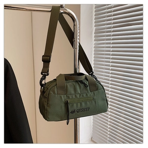 Vue détaillée du sac bandoulière vert olive avec logo de marque et texture en tissu ripstop