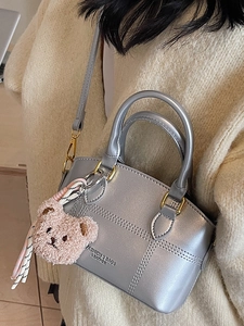 Silberne Metallic-Handtasche mit Teddybär-Anhänger und stilvollen Nahtdetails
