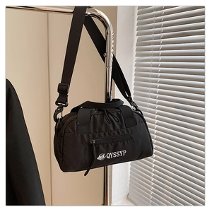 Détail de la texture en nylon durable et de la bandoulière réglable sur le sac à bandoulière noir