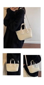 Detail of the woven texture and white leather handles on this chic cream tote bag