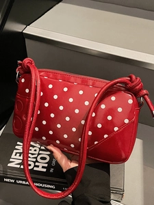Fashionable red polka dot shoulder bag with stylish knotted strap and retro design