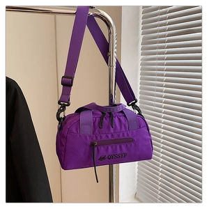 Détail du sac bandoulière en nylon violet imperméable avec sangle réglable et texture fine