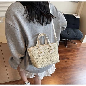Mini straw bucket bag with white leather trim and gold rivets shown in a lifestyle setting