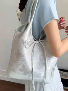 Minimalist beige tote bag with butterfly prints and side bow on white background