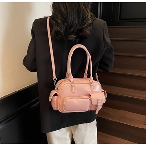 Rückansicht einer rosa Hochglanz-Bowlingtasche an einem Model im schwarzen Blazer
