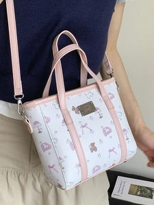 Pink and white cartoon print tote bag for women worn as a crossbody shoulder bag