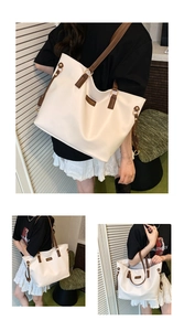 Detail of cream tote bag featuring brown faux leather straps and gold metal hardware rings