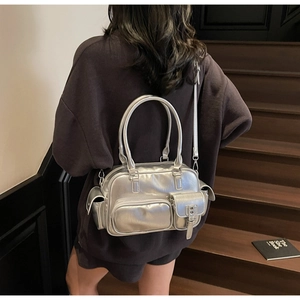 Rückansicht einer silbernen Bowlingtasche aus Metall an einem Modell mit langem Schultergurt