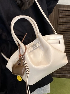 Minimalist cream white dumpling tote bag with gathered pleats and metal buckle detail