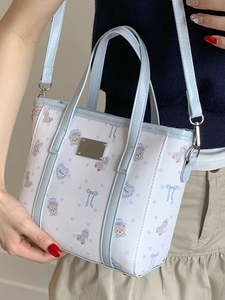 Blue and white tote bag with bear print, leather trim and metal plate detail