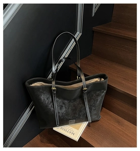 Détail d'un grand sac cabas vintage en cuir PU noir avec bandoulières réglables et logo