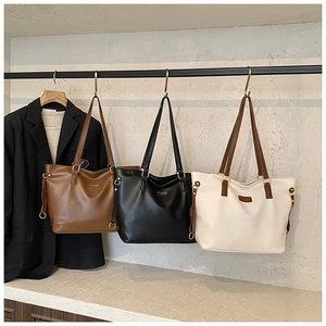 Detailed view of fashionable tote bags in brown, black, and beige leather finishes