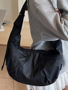 Large black nylon dumpling crossbody bag with adjustable wide strap and front zip pockets