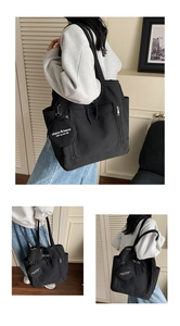 Detail of black canvas tote bag with multi-pocket design and small coin purse attachment